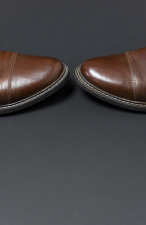 Classic brown leather men's shoes on gray black background top view flat lay with copy space. Fashion male concept, genuine leather shoes. Store advertisement, sale, shopの写真素材