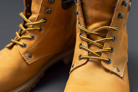 Close-up Yellow men's work boots from natural nubuck leather on gray black background. Trendy casual...