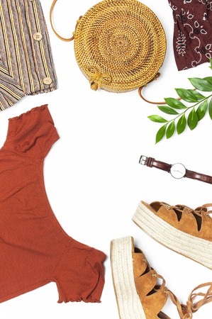 Stylish trendy feminine summer clothing skirt jacket suede sandals round rattan bag shawl wrist watch on white background. Female fashion background beauty or fashion blog concept Flat lay top view.の写真素材