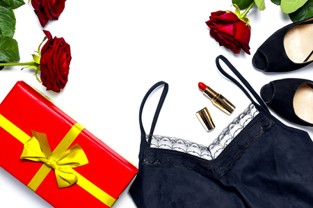 Female black T-shirt jacket with lace, classic shoes, gift box, red lipstick and rose flowers on white background top view flat lay. Beauty fashion background. Sexy clothes, women's holidayの写真素材