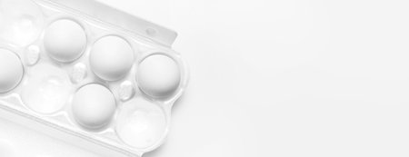White chicken eggs in white packaging on light background top view flat lay copy space. Eggs in box, natural healthy food and organic farming concept. Creative food minimalistic background, Easter.の写真素材