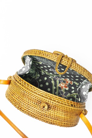 Fashionable handmade natural organic rattan bag on white background. Ladies bag made of natural material. Flat lay, top view, copy space. Ecobags from Bali. Stylish rattan bag.の写真素材
