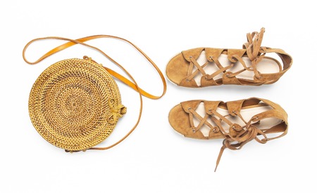 Fashionable handmade natural organic rattan bag, sandals on white background. Ladies bag Female fashion background. Flat lay, top view, copy space. Ecobags from Bali. Stylish rattan bag.の写真素材