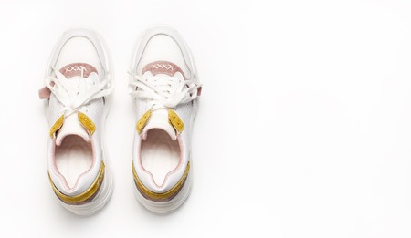 White female sneakers on white background. Women Fashion blog or magazine concept.  shoes, trendy sneakers, fashion, style, lifestyle.の写真素材