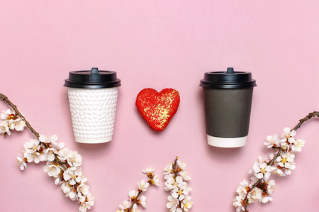 White and brown Coffee or tea paper cup, heart-shaped macaroon cakes on pink background top view flat lay. Take away coffee cup, mockup. Coffee love concept, layout for design, Lifestyle.の写真素材