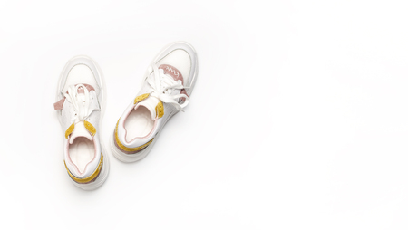 White female sneakers on white background. WomenFashion blog or magazine concept.  shoes, trendy sneakers, fashion, style, lifestyle.の写真素材