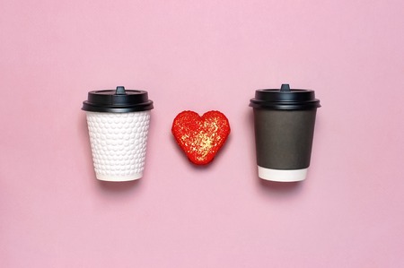 White and brown Coffee or tea paper cup, heart-shaped macaroon cakes on pink background top view flat lay. Take away coffee cup, mockup. Coffee love concept, layout for design, Lifestyle.の写真素材