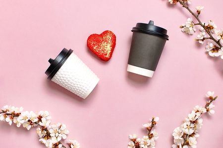 White and brown Coffee or tea paper cup, heart-shaped macaroon cakes on pink background top view flat lay. Take away coffee cup, mockup. Coffee love concept, layout for design, Lifestyle.の写真素材