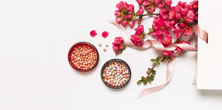 Ball blush rouge and face powder, makeup brush, spring pink flowers in white gift package on light background top view flat lay. Different makeup cosmetic. Beauty fashion background shopping concept.の写真素材