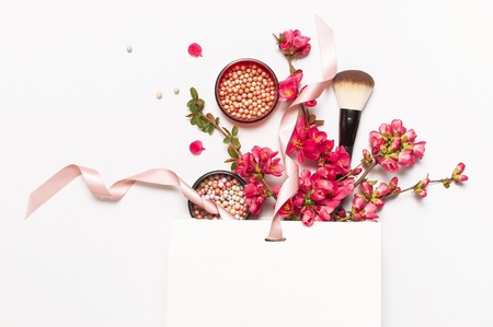 Ball blush rouge and face powder, makeup brush, spring pink flowers in white gift package on light background top view flat lay. Different makeup cosmetic. Beauty fashion background shopping concept.の写真素材