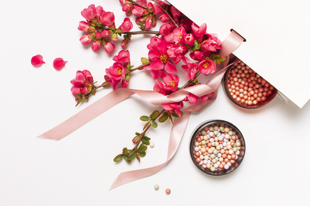 Ball blush rouge and face powder, makeup brush, spring pink flowers in white gift package on light background top view flat lay. Different makeup cosmetic. Beauty fashion background shopping concept.の写真素材