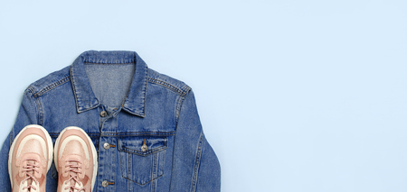 Blue denim jacket and trendy pink sneakers on blue background top view flat lay copy space. Denim, fashionable jacket women's or men's trend clothing, fashion beauty background. Spring Fashion Concept.の写真素材
