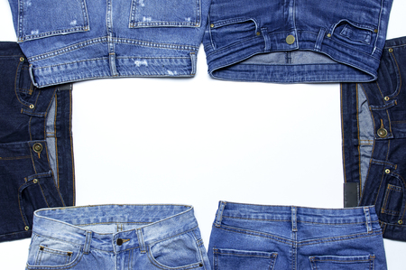 Frame of different blue jeans isolated on white background top view flat lay. Detail of nice blue jeans. Jeans texture or denim background. Trend clothing. Beauty and fashion, clothing conceptの写真素材