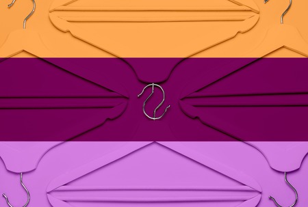 Creative fashion concept. Flat lay top view colored wooden hangers on multi-colored background minimalism style pop-art. Sale discount store shopping concept, design empty hanger feminine blog.の写真素材