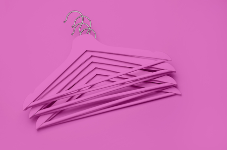Creative fashion concept. Flat lay top view colored wooden hangers on pink background minimalism style pop-art. Sale discount store shopping concept, design empty hanger. Beauty feminine blog.の写真素材