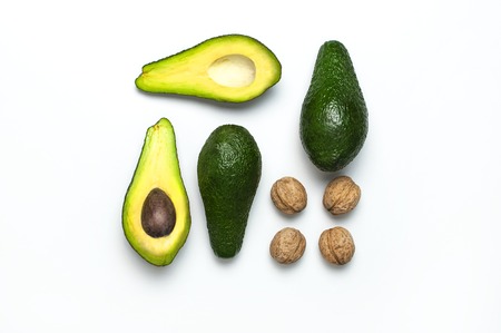 Ripe fresh avocado and walnuts on white background top view Flat lay copy space. Fruits Healthy food concept, diet, healthy lifestyleの写真素材