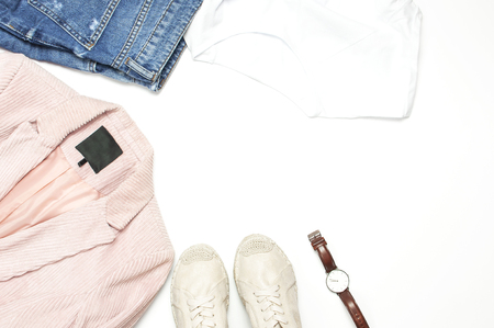 Stylish feminine spring clothing white shirt, blue jeans, pink corduroy jacket, beige espadrilles, watches on white background. Trendy hipster look. Female background blog concept Flat lay top view.の写真素材