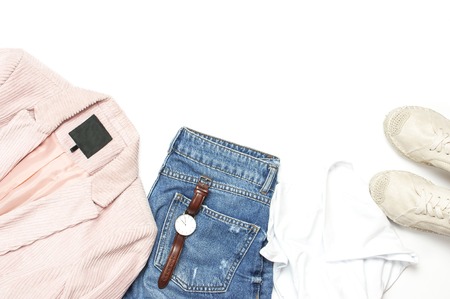 Stylish feminine spring clothing white shirt, blue jeans, pink corduroy jacket, beige espadrilles, watches on white background. Trendy hipster look. Female background blog concept Flat lay top view.の写真素材