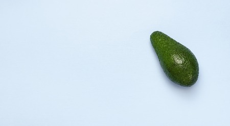 Ripe fresh avocado on pastel blue background top view Flat lay copy space. Fruits Healthy food concept, diet, healthy lifestyleの写真素材