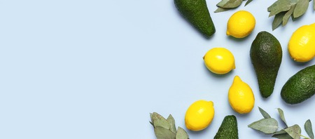 Ripe fresh avocado, fresh citrus lemons, eucalyptus twigs on pastel blue background top view Flat lay copy space. Fruits Healthy food concept, diet, healthy lifestyle. Creative food background.の写真素材