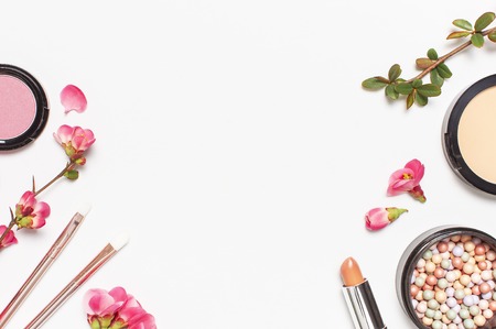 Different makeup cosmetic. Ball blush   face powder lipstick concealer bottle of perfume eyeshadow makeup brush spring pink flowers on light background top view flat lay. Beauty fashion background.の写真素材