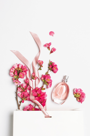 Bottle of women's perfume with pink spring flowers white gift package on light background top view flat lay copy space. Perfumery cosmetics female accessories fragrance collection. Pink Perfume.の写真素材