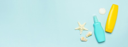 Summer concept, marine background. Seashells, starfish, sunscreen body cream spray on pastel blue background. Top view, flat lay, copy space. Sea summer vacation Mockup. Travel, marine souvenir.の写真素材