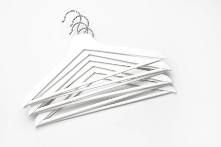Flat lay top view White wooden hangers on white background copy space minimalism style. Sale discount store shopping concept, design empty hanger. Creative fashion beauty background. Feminine blog.の写真素材