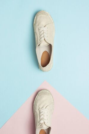 Beige fashionable women's espadrilles on color pastel blue pink background. Creative concept of spring shoes, fashion blog or magazine concept Flat lay top view copy space.の写真素材