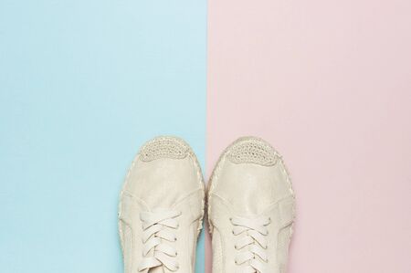 Beige fashionable women's espadrilles on color pastel blue pink background. Creative concept of spring shoes, fashion blog or magazine concept Flat lay top view copy space.の写真素材