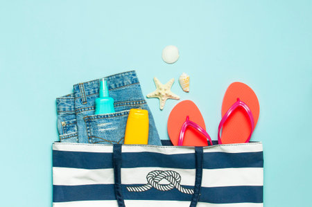 Summer sea accessories. Beach bag Coral flip flops denim shorts shells starfish sunscreen bottle...