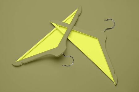 Creative fashion concept. Flat lay top view colored wooden hangers on khaki lemon yellow background minimalism style pop-art. Sale discount store shopping concept, design empty hanger. Feminine blog.の写真素材