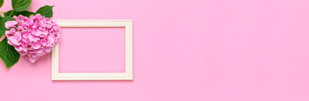 Beautiful pink hydrangea flowers, white wooden photo frames on pink background top view flat lay...