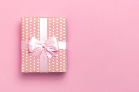 Gift or present box with beautiful festive ribbon on pink background top view. Flat lay composition for celebration, holiday, birthday, Valentines Day, March 8, mother day, wedding. Congratulation.の写真素材