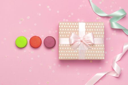 Gift or present box beautiful festive ribbon cake macaron or macaroon confetti on pink background top view. Flat lay composition for celebration holiday birthday, Valentines Day, March 8, mother day.の写真素材