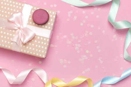 Gift or present box beautiful festive ribbon cake macaron or macaroon confetti on pink background top view. Flat lay composition for celebration holiday birthday, Valentines Day, March 8, mother day.の写真素材