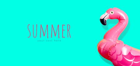 Creative summer beach concept. Inflatable pink mini flamingo on blue emerald background, pool float party. Flat lay, copy space. Flamingo Trend Inflatable Toy. Summer background. Layout for design.の写真素材