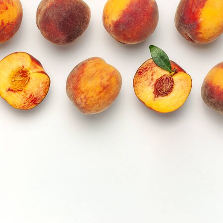Flat lay composition with peaches. Ripe juicy peaches with green leaves on white background. Flat lay, top view, copy space.の写真素材