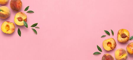 Flat lay composition with peaches. Ripe juicy peaches with green leaves on pink background. Flat lay, top view, copy space.の写真素材