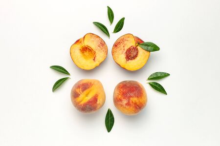 Flat lay composition with peaches. Ripe juicy peaches with green leaves on white background. Flat lay, top view, copy space.の写真素材
