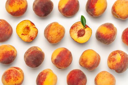 Flat lay composition with peaches. Ripe juicy peaches with green leaves on white background. Flat lay, top view, copy space.の写真素材