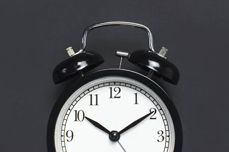 Black retro alarm clock on gray dark backgroundの写真素材