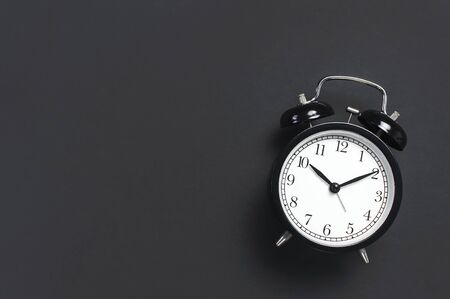 Black retro alarm clock on gray dark backgroundの写真素材