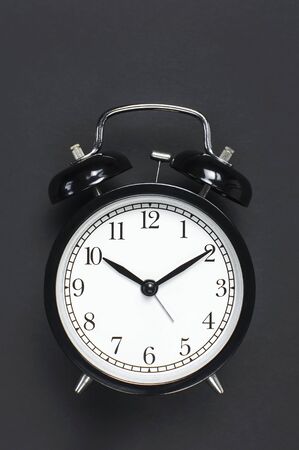 Black retro alarm clock on gray dark backgroundの写真素材