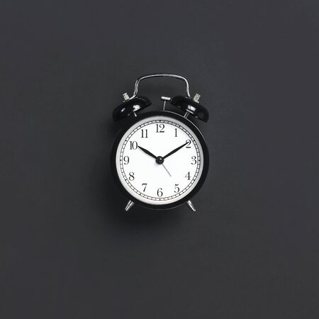 Black retro alarm clock on gray dark backgroundの写真素材