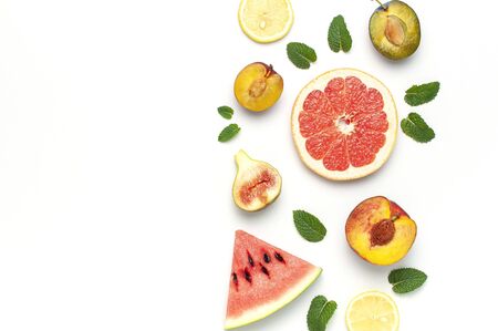 Tropical Summer Fruit Concept. Creative layout made of fresh ripe watermelon, peach, plum, fig, lemon, grapefruit and mint leaves on white background. Flat lay, top view, copy space. Food background.の写真素材