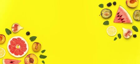 Tropical Summer Fruit Concept. Creative layout made of fresh ripe watermelon, peach, plum, fig, lemon, grapefruit and mint leaves on yellow background. Flat lay, top view, copy space. Food background.の写真素材