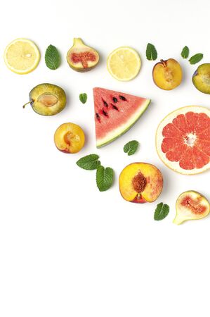 Tropical Summer Fruit Concept. Creative layout made of fresh ripe watermelon, peach, plum, fig, lemon, grapefruit and mint leaves on white background. Flat lay, top view, copy space. Food background.の写真素材