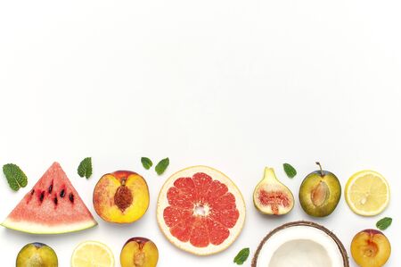Tropical Summer Fruit Concept. Creative layout made of fresh ripe watermelon, peach, plum, fig, lemon, grapefruit and mint leaves on white background. Flat lay, top view, copy space. Food background.の写真素材