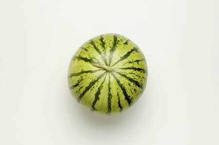Ripe watermelon berry with a tail on light gray backgroundの写真素材